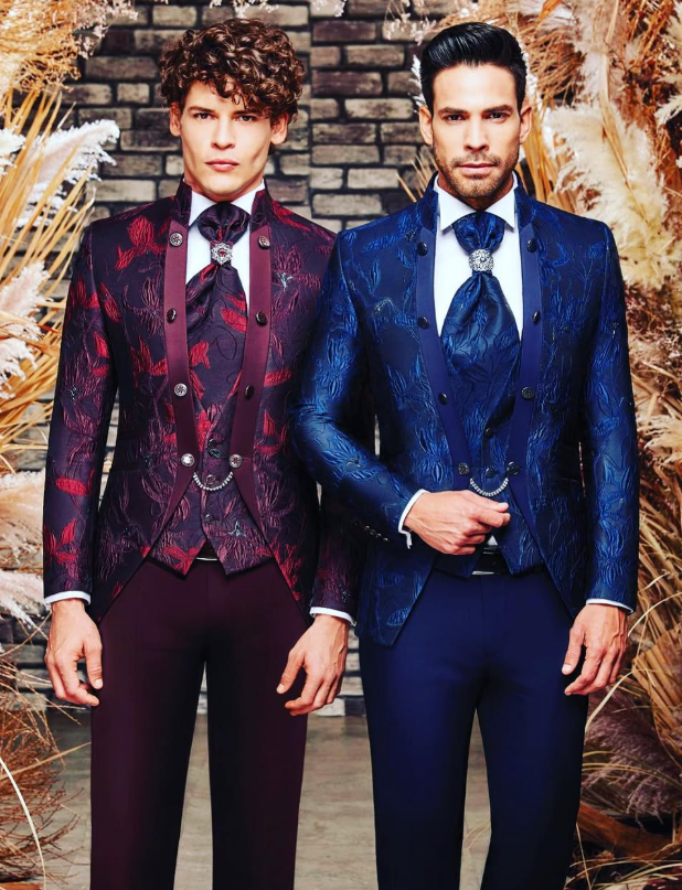 Dos modelos con trajes de jacquard burdeos y azul de tres piezas